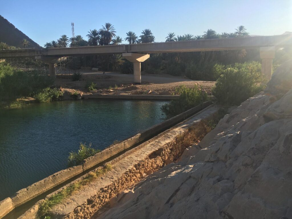 The wadi facing the bridge in Ait Rehal nearby the town of Akka, Morocco. The wadi is dammed against the bridge to allow traffic to drive across.
